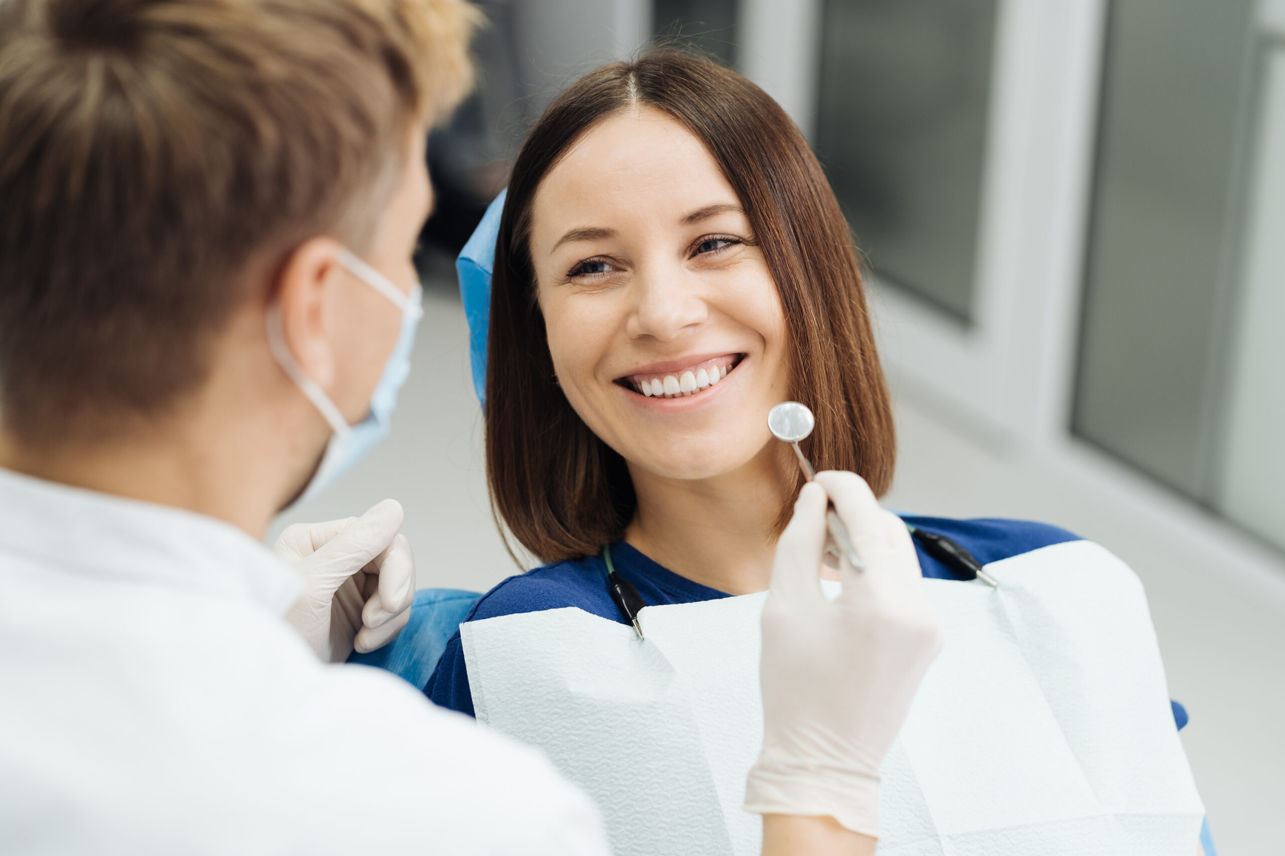 male-professional-dentist-with-gloves-mask-discuss-what-treatment-will-look-like-patient-s-teeth-scaled.jpg